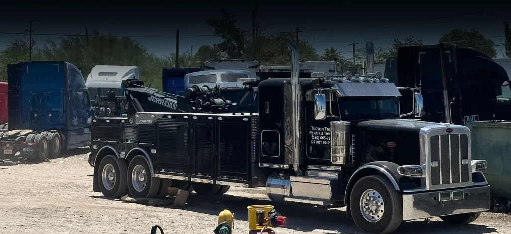 a black tow truck parked on a road