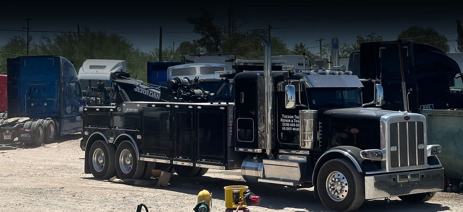 a black tow truck parked on a road