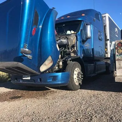 a blue semi truck with its hood open